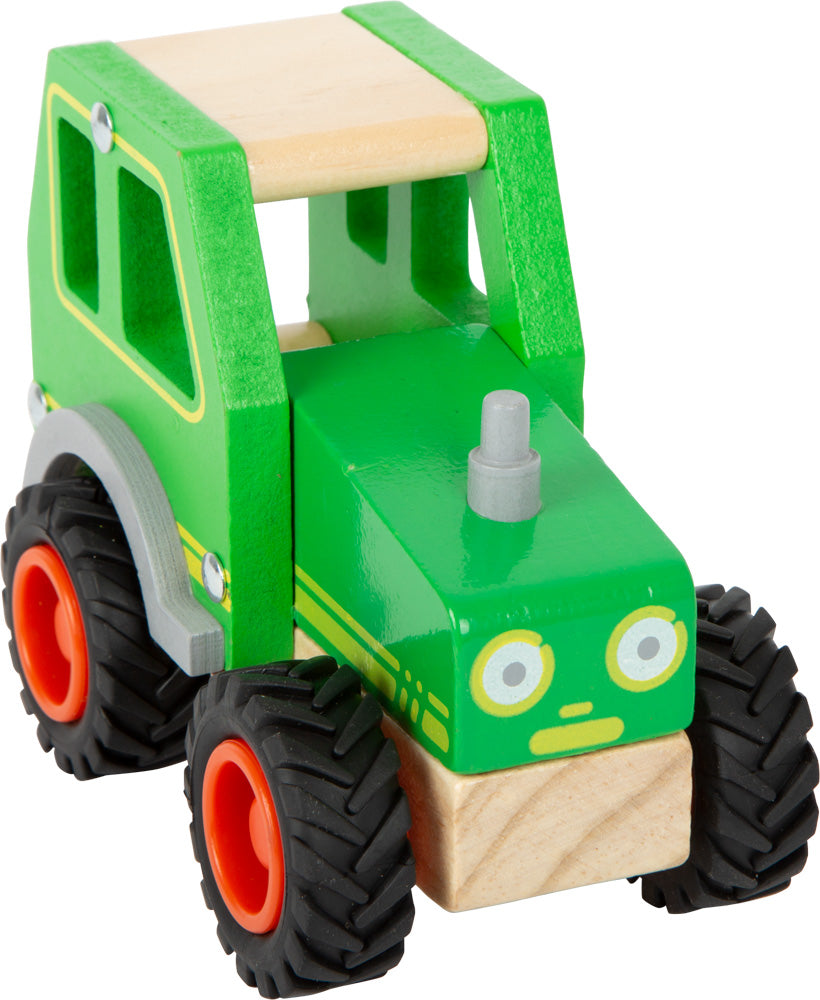 Schöner Holz-Traktor in grün mit gummierten Rrifen und fröhlichem Gesicht